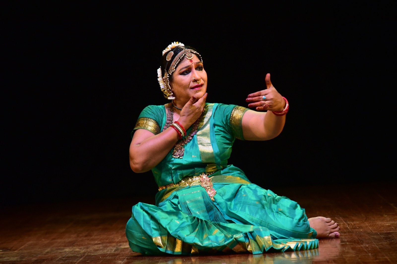 Narthaki Nataraj reaching forward with one hand during an expressive Bharatanatyam performance